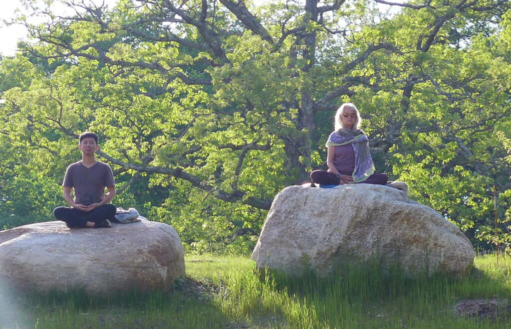 Two people meditating on large rocks