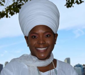 A smiling woman in a white turban