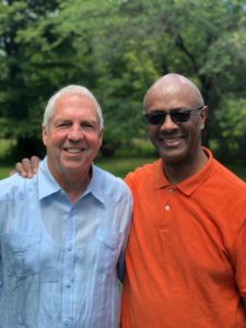 Two smiling men one in a blue shirt and one in a red shirt