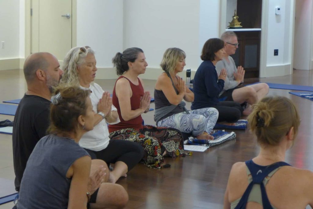 a group of people in prayerful posture