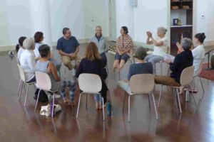 People sit on chairs in a circle laughing