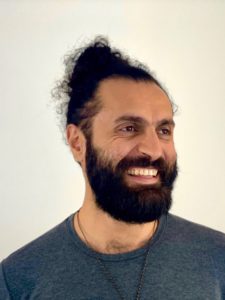 smiling man with full beard and topknot