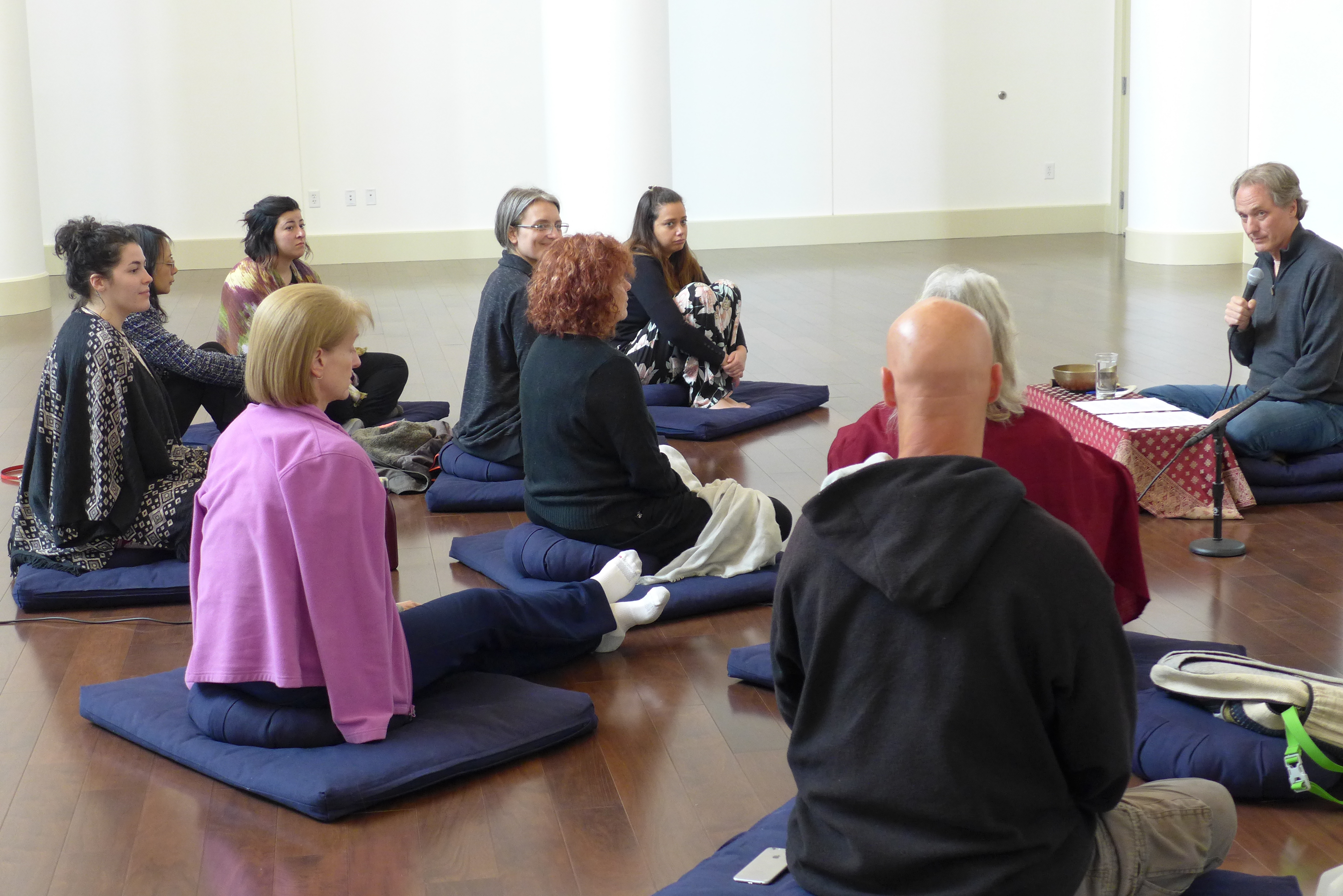 man talking ot a group seated on the floor