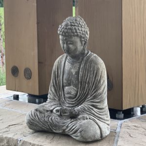 A close up picture of a stone Buddha in meditation posture