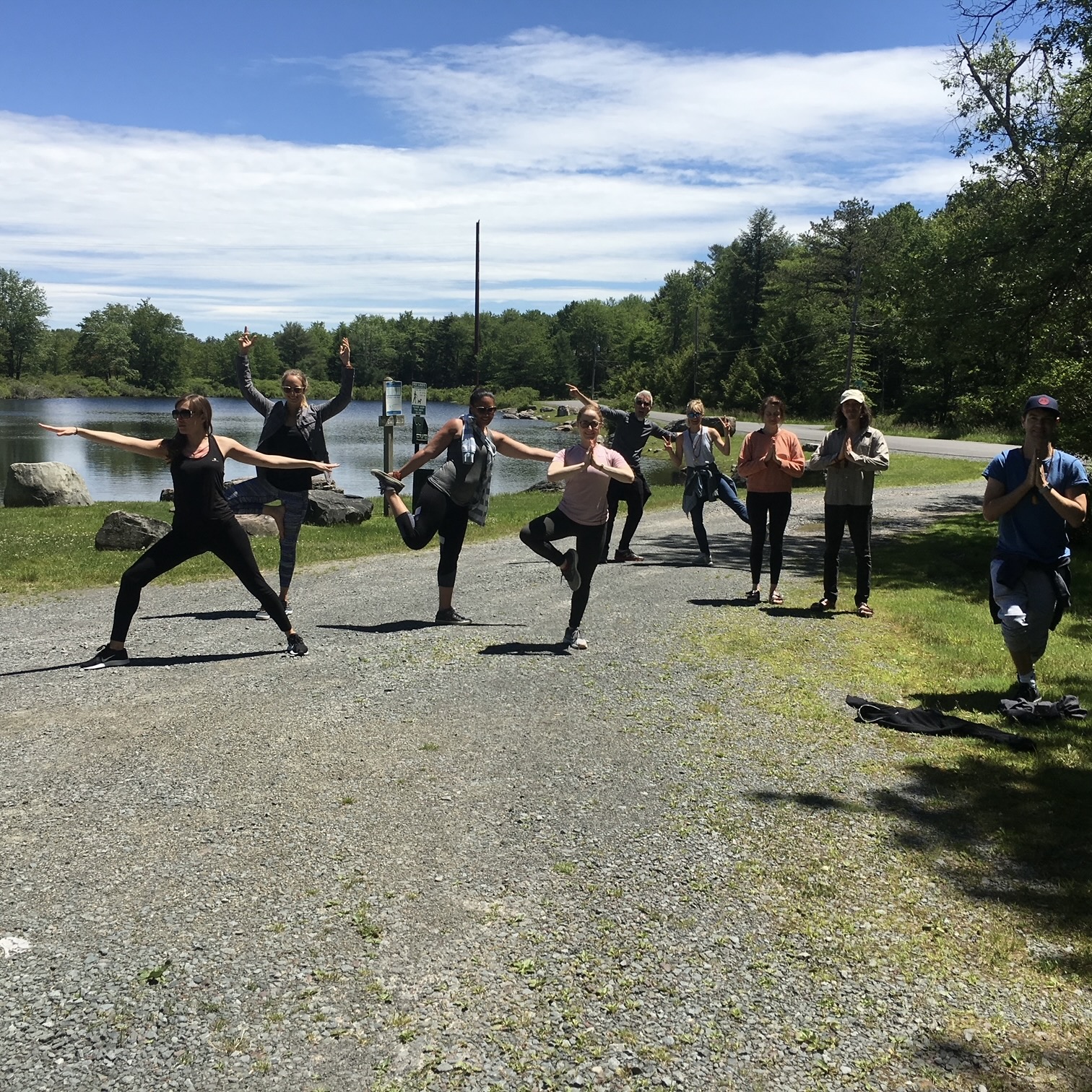 a group of peopel practicing yoga by a pond