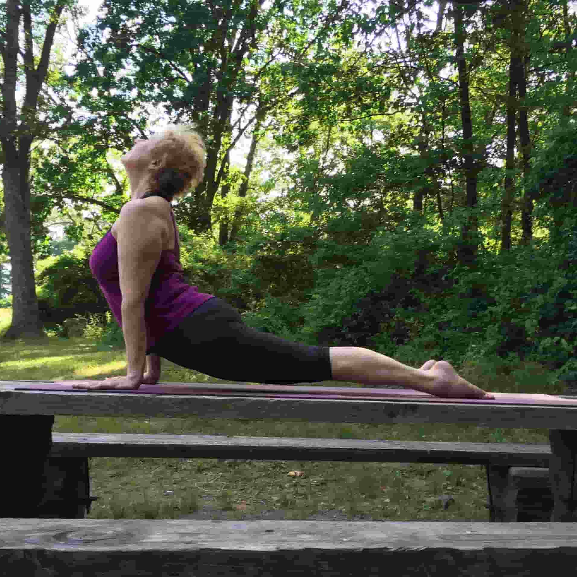 woman in Cobra position in tree-shaded locale