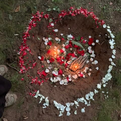 rose petals scattered in a heart shape around a fire