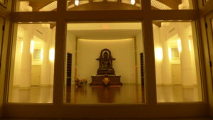Buddha statue seen through a window at night