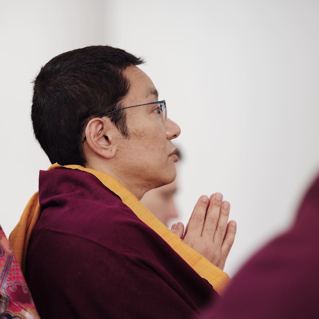 a monk in Tibetan robes praying